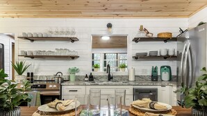 A modern kitchen with wooden cabinets, stainless steel appliances, and a central island with seating. - Creekside Adventure! 10 steps from the cascading and gentle Fightingtown Creek (Blue Ridge)