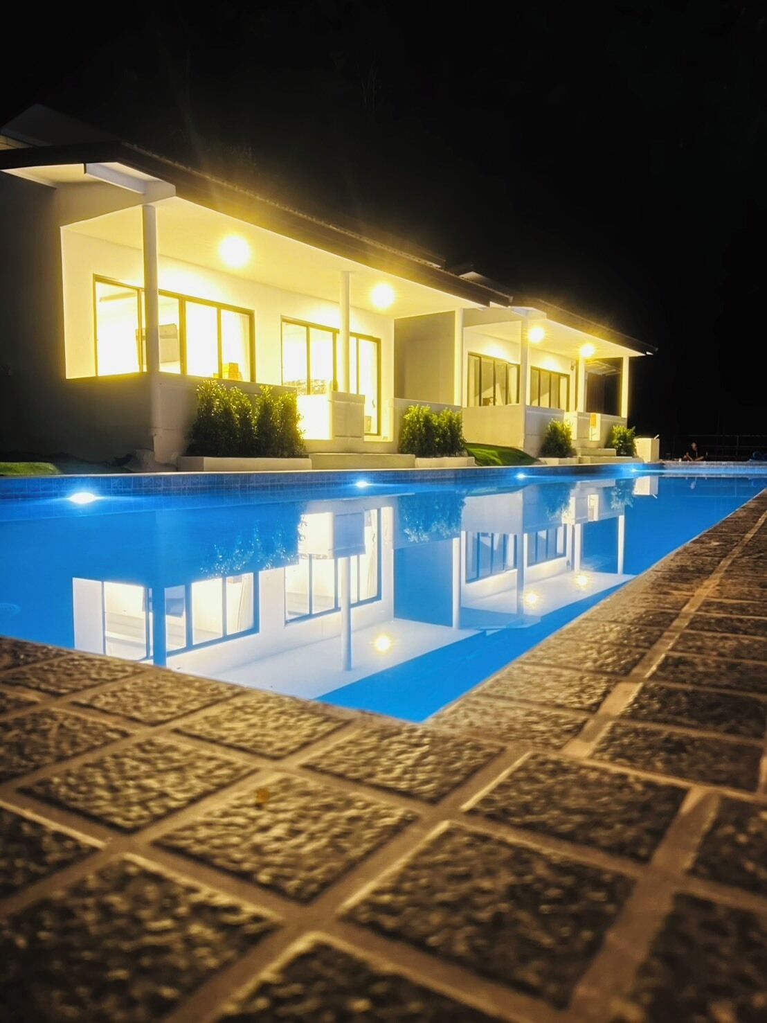 A modern house with a swimming pool at night.