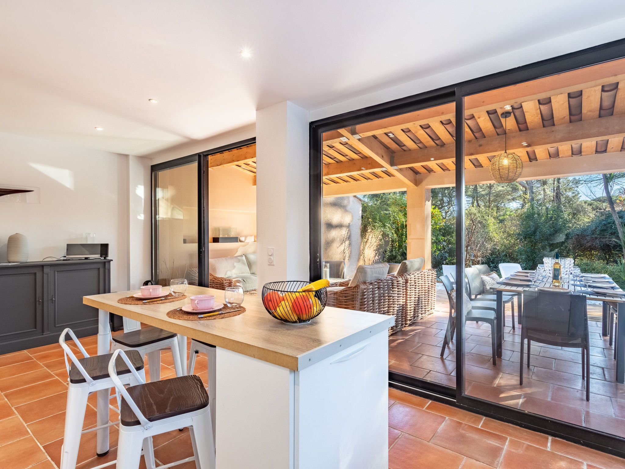 An open-plan kitchen and dining area with a large sliding glass door leading to an outdoor patio.