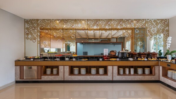 A modern buffet setup with a decorative wall and a large mirror. - Swiss-Belexpress Yogyakarta (Yogyakarta)