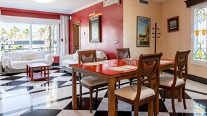Comedor con suelo a cuadros, una mesa roja y sillas de madera.