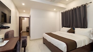 A hotel room with a bed, a desk, and a TV. - Hotel Park Royale Inn (Dehradun)