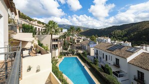 A residential area with a swimming pool, white buildings, and a mountainous backdrop. - El Casar Townhouse Benahavis (Benahavis)
