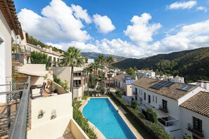 A residential area with a swimming pool, white buildings, and a mountainous backdrop. - El Casar Townhouse Benahavis (Benahavis)