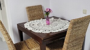A dining table with a white lace tablecloth, surrounded by four wicker chairs. - VAO Holiday Rental-los Narejos by Oasis (Los Alcazares)
