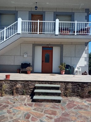 A two-story building with a stone facade, a wooden door, and a balcony with white railings. - Cozy Cottage in Country Side (Bóveda)