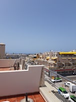 Terraço no terraço com vista para o horizonte urbano, incluindo edifícios e uma rua com carros.