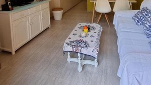 Un espacio habitable compacto con televisor, un pequeño comedor y un sofá.