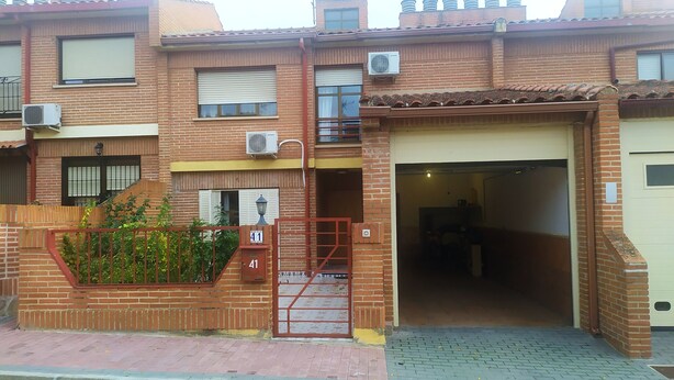 Un edificio residenziale a più piani con facciata in mattoni, ingresso carrabile e garage.