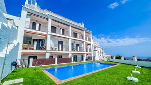 Un hôtel à plusieurs étages doté d’une piscine et d’une pelouse bien entretenue.
