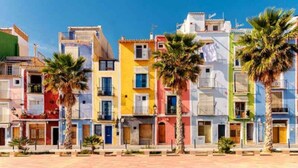 Un conjunto de edificios coloridos con balcones y palmeras en primer plano.