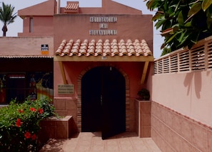 L’entrée d’un immeuble d’habitation, avec une enseigne indiquant « RÉSIDENCE LAS BUGANVILLAS » et un panneau indiquant qu’il s’agit d’une propriété privée.
