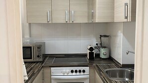 A compact kitchen with a built-in oven, microwave, and a washing machine. - Stunning two Bedroom Apartment in Salou (Salou)