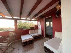 A covered outdoor seating area with a sofa, chairs, and a table. - Sunset and Oceanview 1 Bedroom Apartment With Shared Pool (San Bartolomé de Tirajana)