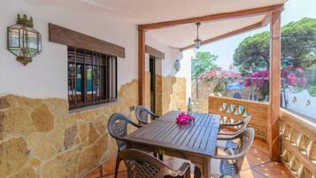 Relax in a serene outdoor space with a table and chairs under a covered pergola.