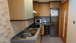 A compact kitchen with a sink, microwave, toaster, and stainless steel refrigerator. - Lovely 2 Bedroom, 2 Bathroom Apartment With Pool (Roquetas de Mar)