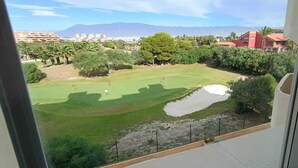 A view of a golf course with a pond, surrounded by trees and buildings. - Lovely 2 Bedroom, 2 Bathroom Apartment With Pool (Roquetas de Mar)