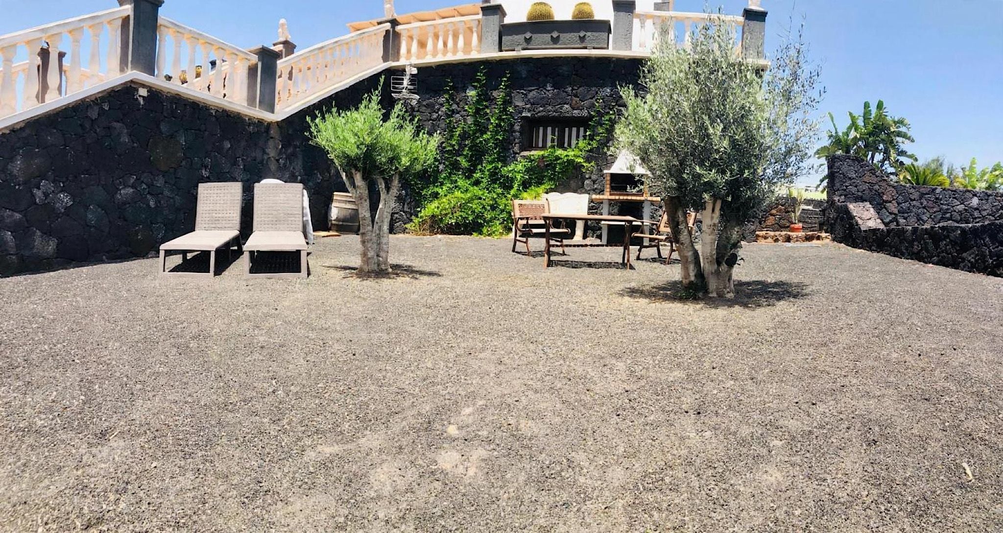 Ein Innenhof mit einer Steinsäule, einer Holzbank und einem Tisch.