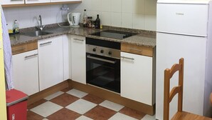 A compact kitchen with white cabinets, a microwave, a stove, and a refrigerator. - 2 Bd Apartment With Stunning View (Santiago del Teide)