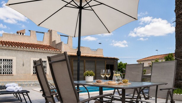An outdoor patio with a pool table, chairs, and a table set with drinks and snacks. - Townhouse With Shared Pool (Torrevieja)