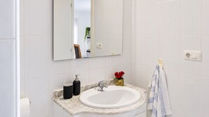 A bathroom with a white sink, a mirror, and a towel rack. - Townhouse With Shared Pool (Torrevieja)