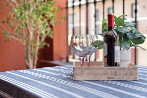 Una botella de vino y una copa vacía sobre una mesa con mantel a rayas, rodeadas por una bandeja de fibras.
