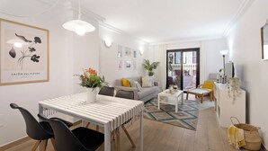 A modern living room with a dining area, featuring a white sofa, a coffee table, and a dining table with chairs. - Bonito Apto Montenerife Adeje (Adeje)