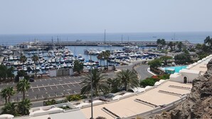 Ein Yachthafen mit vertäuten Booten, eine Straße und ein Poolbereich.