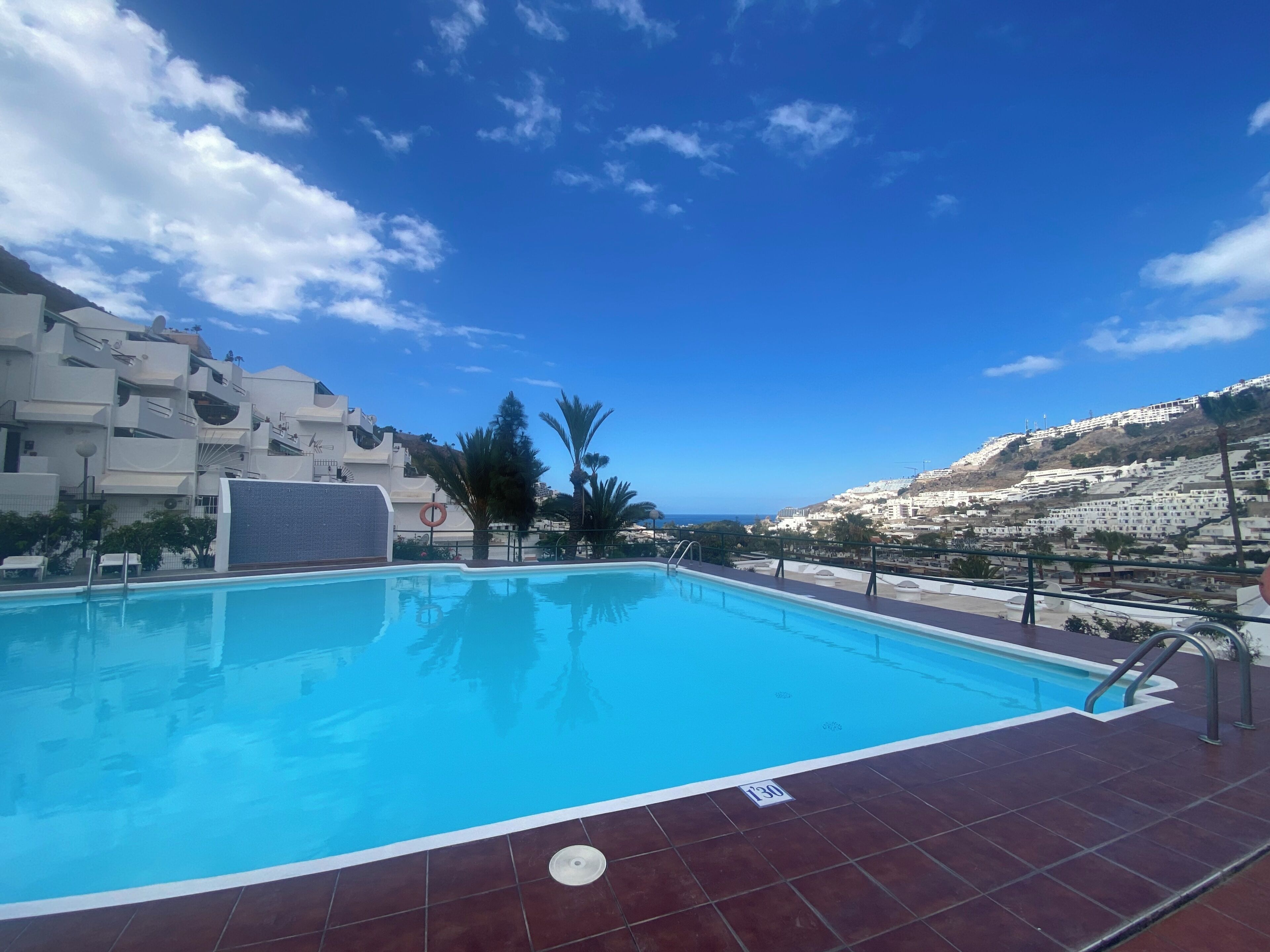 A swimming pool with a clear view of a mountainous landscape in the background.