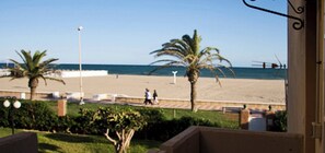 A beach view with palm trees and a clear sky. - Apartment In Complex Don Paco - On Front Line Of The Beach (Roquetas de Mar)