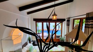 Un interior moderno con vistas despejadas a una piscina exterior, vigas de madera y un farol colgante.