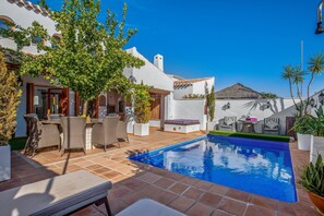 A pool area with a tiled deck, lounge chairs, and a small table. - Special-offer Luxuriousvilla, Baños y Mendigo, Spain-perfect for Families&groups (Murcia)