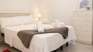 A hotel room with a bed, a nightstand, a lamp, a dresser, and a framed picture on the wall. - Charming House With Nature (Torrevieja)