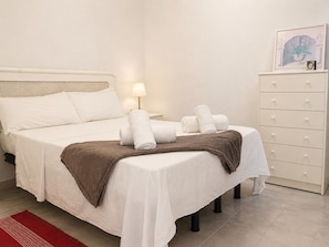 A hotel room with a bed, a nightstand, a lamp, a dresser, and a framed picture on the wall. - Charming House With Nature (Torrevieja)