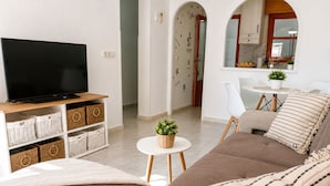 A living room with a TV, sofa, and coffee table. - Charming House With Nature (Torrevieja)