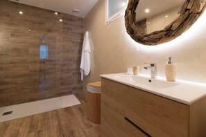 A modern bathroom with a wooden vanity, a large mirror, and a shower area with wooden flooring. - Room-private Room in the Fishing Port of (Marbella)