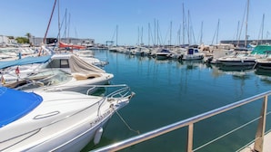A marina with various boats docked, a clear sky, and a building in the background. - Room in Guest Room - Private Room in the Fishing Port of Marbella (Marbella)
