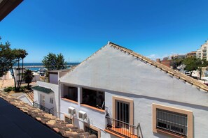 A white building with a sloped roof, a balcony, and a view of the sea. - Room-private Room in the Fishing Port of (Marbella)