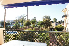 A balcony with a view of a pool and surrounding greenery. - Apartment 10 Minutes Walk From Puerto Banús (Marbella)
