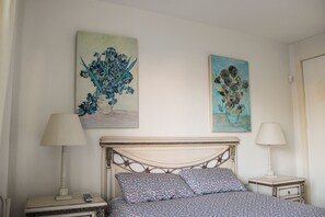 A bedroom with a bed, two bedside tables, two lamps, and two paintings on the wall. - Apartment 10 Minutes Walk From Puerto Banús (Marbella)