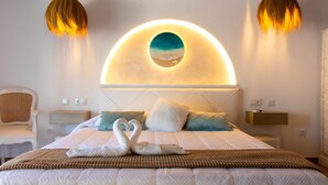 A hotel room with a large bed, a headboard with a circular light, two bedside tables, a chair, and a wall-mounted shelf. - Room in Guest Room - Private Room With Beautiful sea View (Marbella)