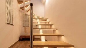 A modern staircase with wooden steps and a metal handrail, leading to a landing with a decorative wall piece. - Room in Guest Room - Private Room With Beautiful sea View (Marbella)