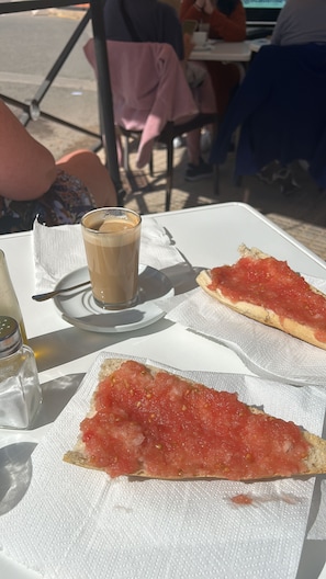 A table with a glass of iced coffee, a slice of pizza, and a napkin. - The Fairways - Luxurious Front Line Villa on Mar Menor Golf Resort (Torre-Pacheco)