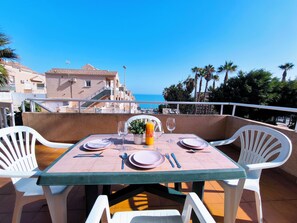 A table set for two with a view of the sea, white chairs, and a tiled floor. - Sea View Bungalow With Pool (Torrevieja)