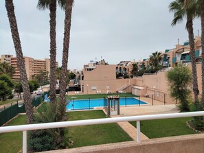 A hotel with a swimming pool, surrounded by palm trees and other greenery. - Sea View Bungalow With Pool (Torrevieja)