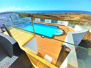 Une piscine sur le toit offrant une vue dégagée sur l’océan et le paysage environnant.