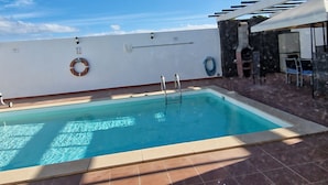 An outdoor swimming pool with a clear blue sky, a lifebuoy, and a ladder. - Villa Georgiana Spacious Quiet 4 Bed Property With Private Pool Sleeps 8 (Yaiza)