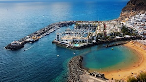 Une ville côtière dotée d’un port de plaisance, d’une plage et de falaises rocheuses.