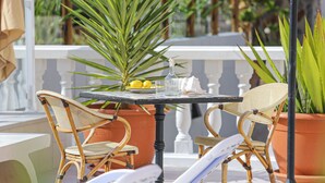 A balcony with wicker chairs, a table, potted plants, and a view of the outdoors. - Playa De Mogan Casa Don Johan B3 (Mogan)