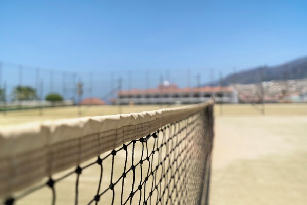 Ein Tennisplatz mit Netz im Vordergrund.